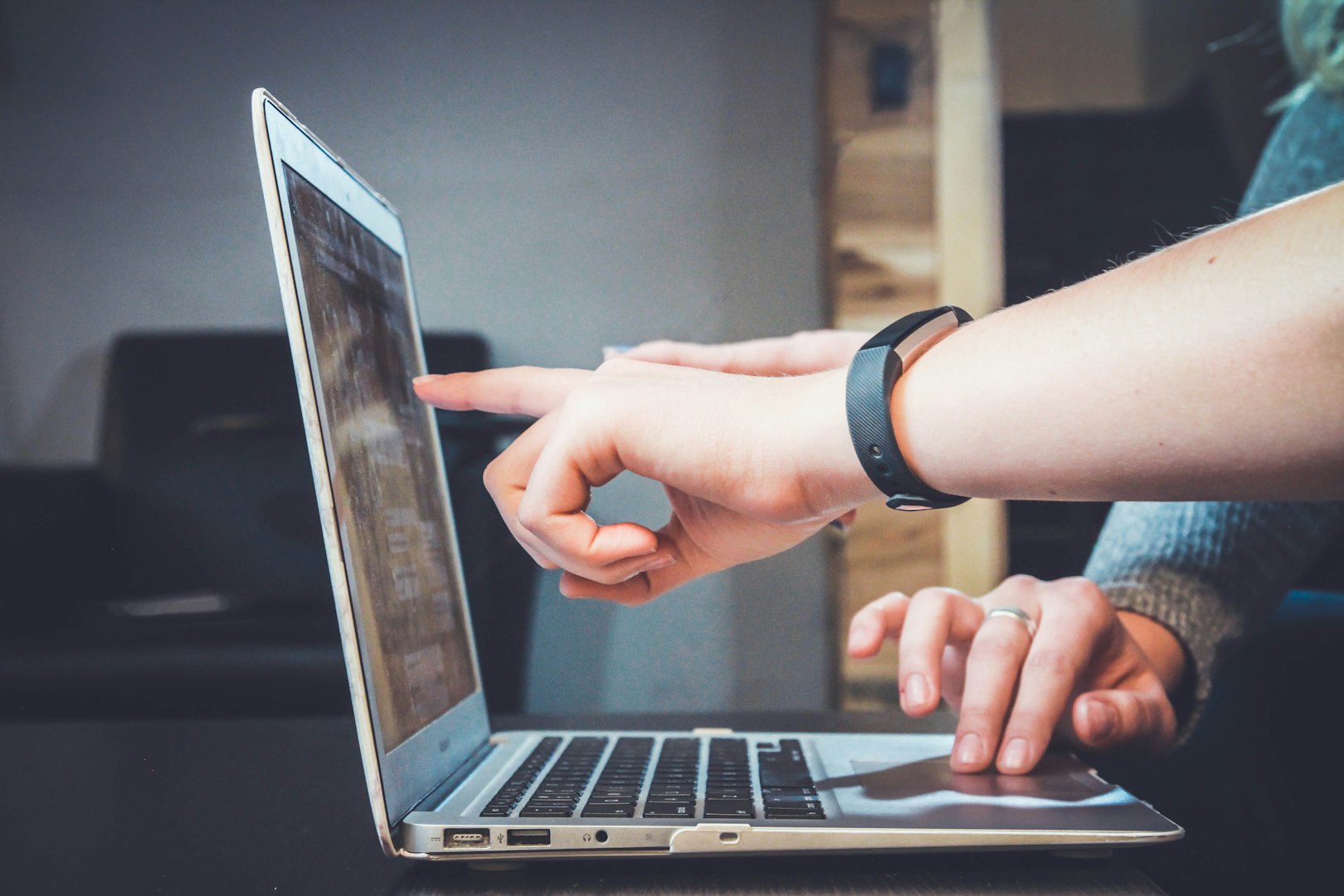 Finger pointing at computer screen